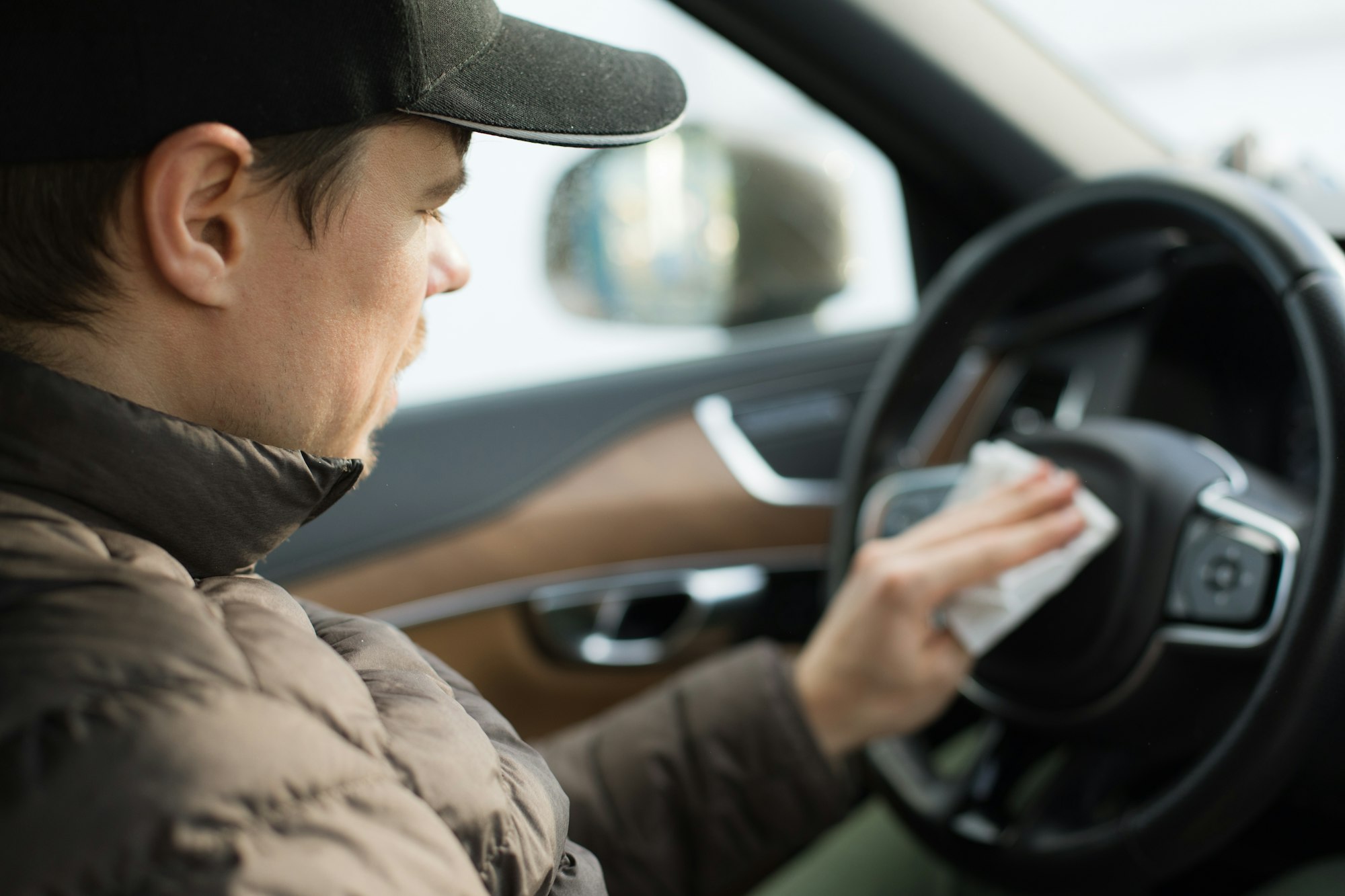 Man cleans the car with a paper towel.