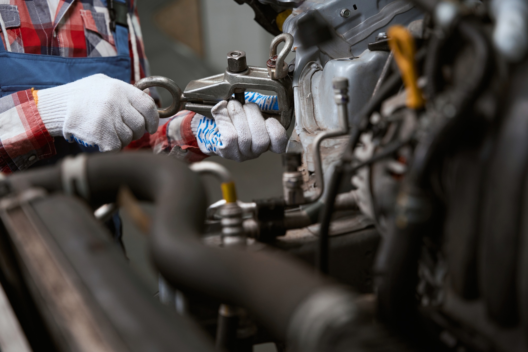 Man in work clothes repairs a car after a breakdown