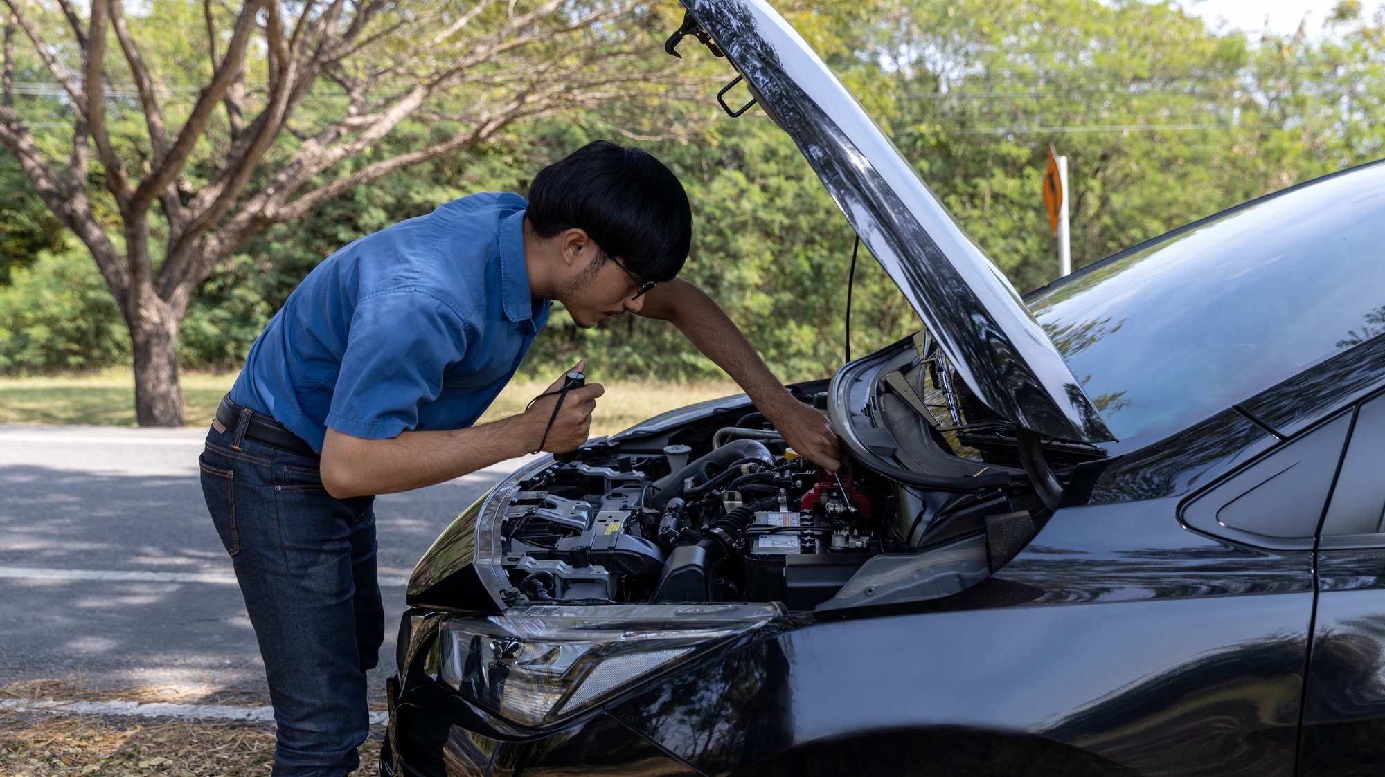 Man is Checking car battery because car battery is depleted. concept car maintenance