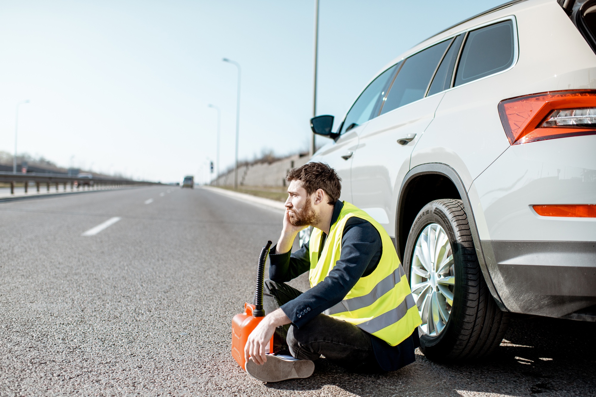 Man with refuel canister near the car on the roadside