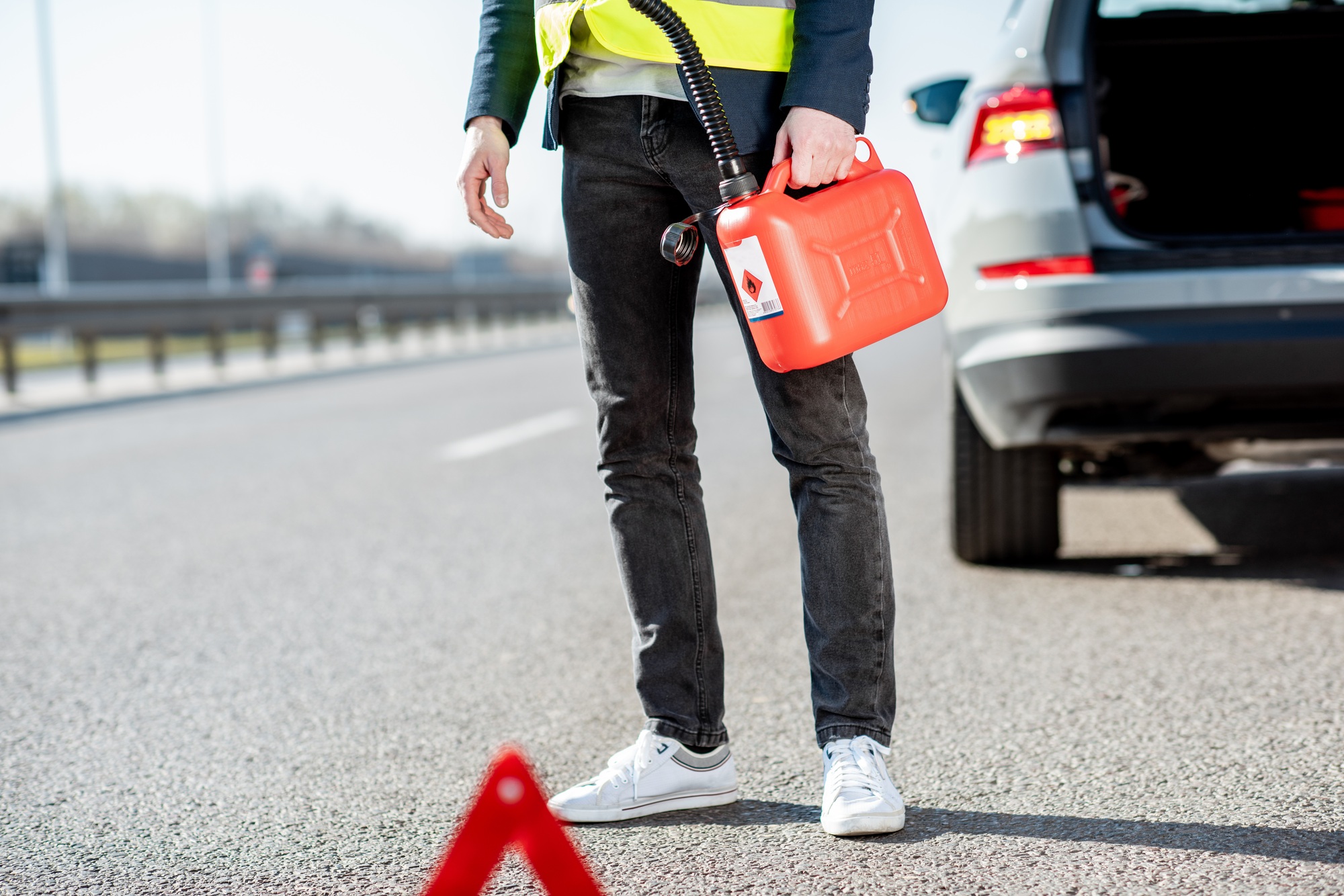 Man with refuel canister on the roadside