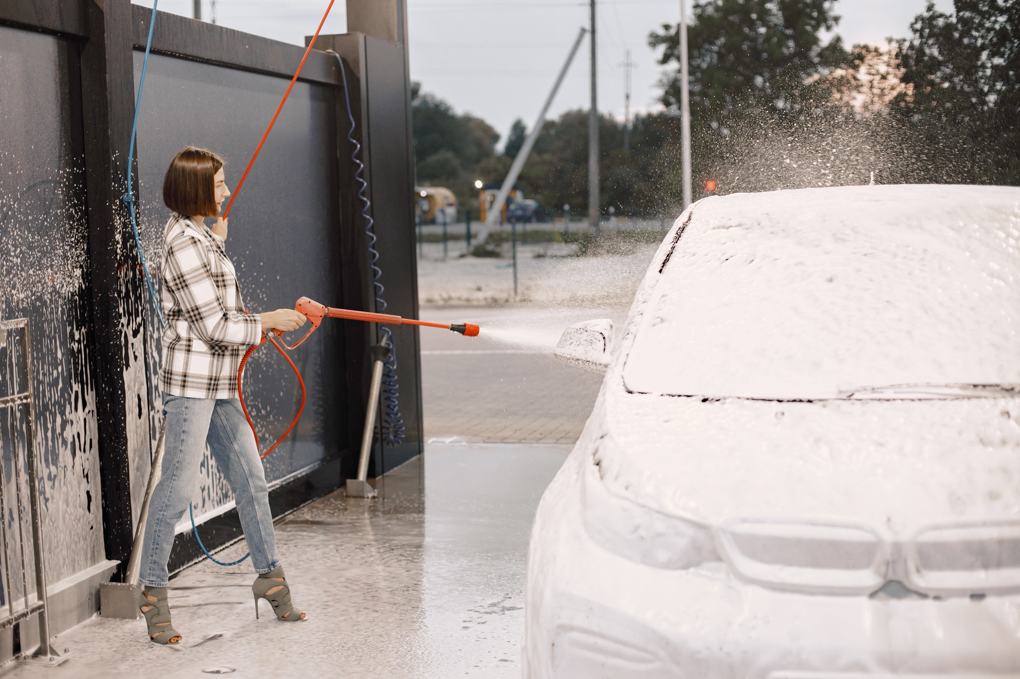 Woman washing her car in the car wash station