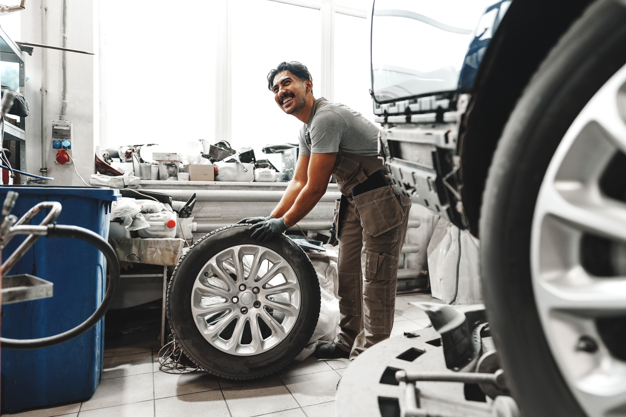 Mechanic pushing a car tire in car service