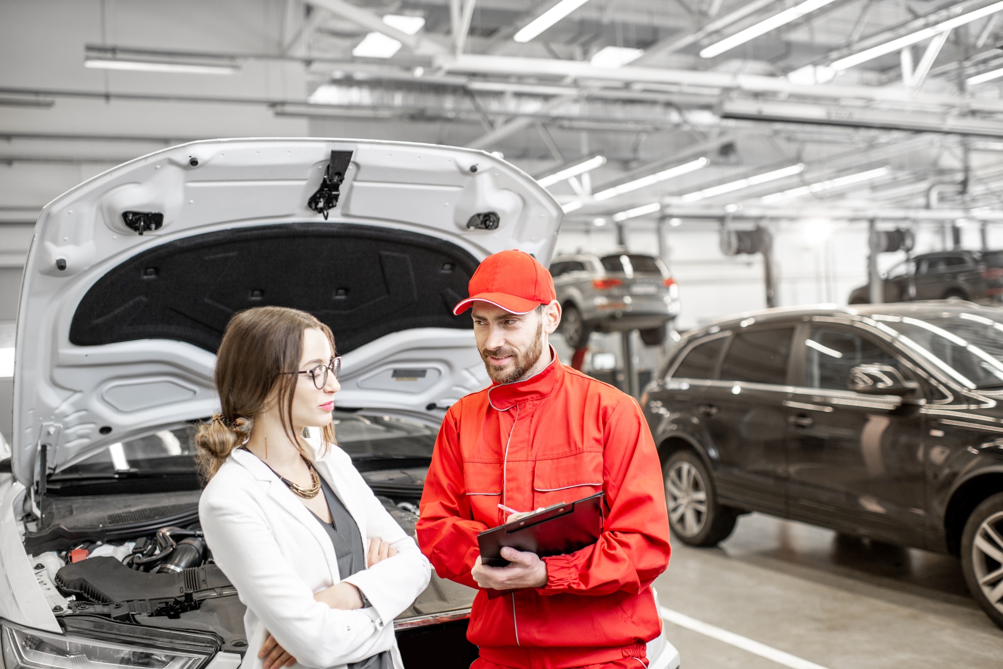 Woman client with auto mechanic at the car service